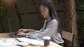 Working outdoor concept a young woman typing on the laptop with a cup of coffee outside the building surrounded by relaxing Royalty Free Stock Photo