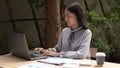 Working outdoor concept a young woman typing on the laptop with a cup of coffee outside the building surrounded by relaxing Royalty Free Stock Photo