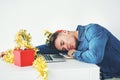 Working over the festive season is such a drag. a handsome young businessman sleeping on his desk while working in his Royalty Free Stock Photo