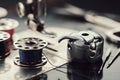 Working part of antique sewing machine. Selective focus on spool of thread, metal shuttle and sewing needles