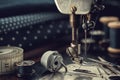 Working part of antique sewing machine with spools of threads, shuttle, measuring tape, sewing needles, scissors. Royalty Free Stock Photo