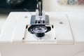 working part of a home sewing machine for handicrafts. Selective focus on plastic shuttle and sewing needle. Close-up Royalty Free Stock Photo