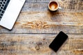 Working place with coffee cup, laptop, phone on wooden table