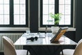 Working place with cup of coffee, notes, open laptop, eye glasses and smartphone on white marble table in the dark modern office Royalty Free Stock Photo