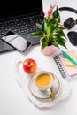 Working place and office desk with coffee, apple, laptop, headset and smarthpone