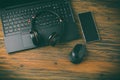 Working place and office desk with laptop, headset, smartphone and computer mouse Royalty Free Stock Photo