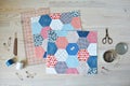 Working process: hexagon quilt, threads, retro scissors, pins, metal jar, quilting ruler and seam ripper