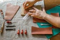 Working process of the leather bag for money or messenger in the leather workshop by master craftsman hands on the table Royalty Free Stock Photo