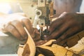 Working process of leather craftsman. Tanner or skinner sews leather on a special sewing machine, close up