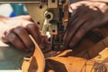 Working process of leather craftsman. Tanner or skinner sews leather on a special sewing machine, close up