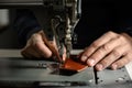 Working process of leather craftsman. Tanner or skinner sews leather on a special sewing machine, close up