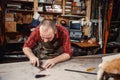 Working process in the leather workshop. Tanner in old tannery.