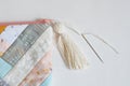 Working process: patchwork bag, cotton tassel and sewing needle on white Royalty Free Stock Photo