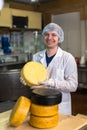 Working on production of cheese at dairy , with cheeses