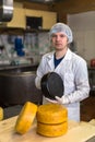 Working on production of cheese at dairy , with cheeses