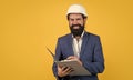 working on project. building concept. builder or engineer in hard hat. happy mature architect in helmet making notes Royalty Free Stock Photo