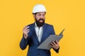 working on project. building concept. builder or engineer in hard hat. surprised mature architect in helmet making notes Royalty Free Stock Photo