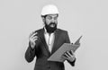 working on project. building concept. builder or engineer in hard hat. surprised mature architect in helmet making notes Royalty Free Stock Photo