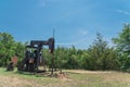 Working pump jack pumping crude oil at oil drilling site in rural USA Royalty Free Stock Photo