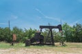 Working pump jack pumping crude oil at oil drilling site in rural USA Royalty Free Stock Photo