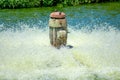 Working rusty pump aerating and filtering contaminated water in wastewater treatment facility pond Royalty Free Stock Photo