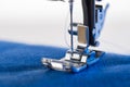 Working sewing machine sewing blue fabric