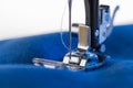 Working sewing machine sewing blue fabric