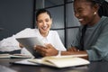 Working smarter to get more done. two businesswomen working together on a digital tablet in an office.