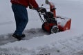 Snow blowing a driveway on a blustery winter day