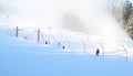 Working snow making machine on ski resort. Snow blower in action. Sunny winter day. Latvia Royalty Free Stock Photo