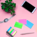 Working space with a clock, telephone, stickers, notes on a pink background. place for text. The working space of a freelancer, jo