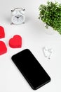 Working table with smart phone, flower, clock ,headphone and red hearts. Top view. flat lay Royalty Free Stock Photo