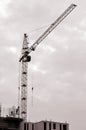 Working tall cranes inside place for with tall buildings under construction against a clear blue sky. Crane and building working Royalty Free Stock Photo