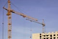 Working tall cranes inside place for with tall buildings under construction against a clear blue sky. Crane and building working Royalty Free Stock Photo