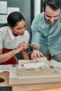 Working on their plans section by section. two architects working together on a scale model of a building in an office. Royalty Free Stock Photo