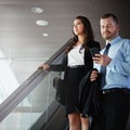 Working their way around the world. a businessman using a mobile phone while traveling down an escalator in an airport. Royalty Free Stock Photo