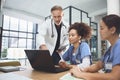 Working together from different clinical disciplines. a team of doctors using a laptop during a meeting in a hospital. Royalty Free Stock Photo