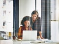 Working together with enthusiasm and passion. two businesswomen working together on a laptop in an office. Royalty Free Stock Photo