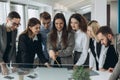 Working together. Group of young modern people in smart casual wear discussing business and smiling in the creative office