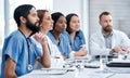 Working together to plan a patients care. Shot of a doctor sitting alongside her colleagues during a meeting in a Royalty Free Stock Photo