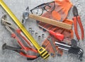 Working tool on a gray concrete surface. Work gloves, hammer, nippers, screwdriver, pliers, screwdriver, hexagonal wrench, ruller