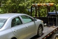 Working in a towing service, loading a damaged car that has been onto a tow truck