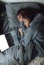 While working using laptop, lady fall asleep on remote project in bedroom. Burnout Syndrome. Overworked and tired young