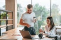 Working by using laptop. Man and woman are in the modern office together Royalty Free Stock Photo