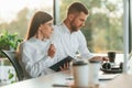 Working by using laptop. Man and woman are in the modern office together Royalty Free Stock Photo