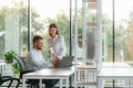 Working by using laptop. Man and woman are in the modern office together Royalty Free Stock Photo