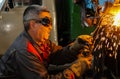 The working welder performs welding work in production using electric arc metal welding.