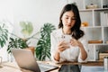 Working woman concept a female manager attending video conference and holding tablet, smatrphone and cup of coffee in home Royalty Free Stock Photo