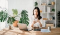 Working woman concept a female manager attending video conference and holding tablet, smatrphone and cup of coffee in home Royalty Free Stock Photo