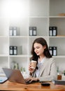 Working woman concept a female manager attending video conference and holding tablet, smatrphone and cup of coffee Royalty Free Stock Photo